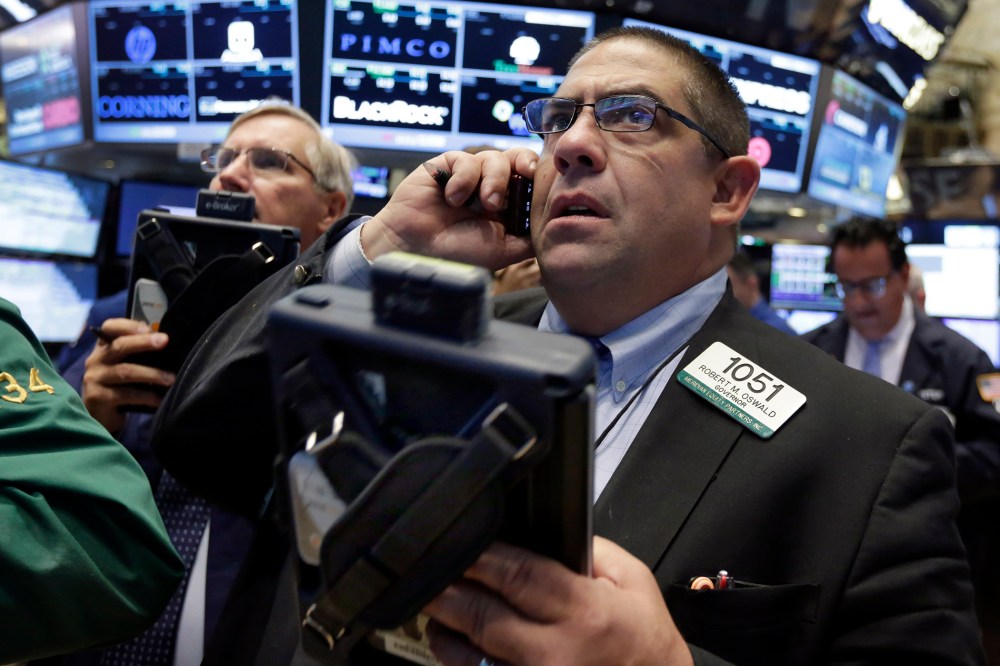 Trader Robert Oswald, right, works on the floor of the New York Stock Exchange, Aug. 26, 2015. (Photo by Richard Drew/AP)