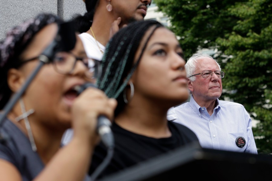 Marissa Johnson, left, speaks as Mara Jacqueline Willaford stands with her and Democratic presidential candidate Sen. Bernie Sanders, I-Vt., stands nearby as the two women take over the microphone at a rally Aug. 8, 2015, in Seattle (Elaine Thompson/AP)