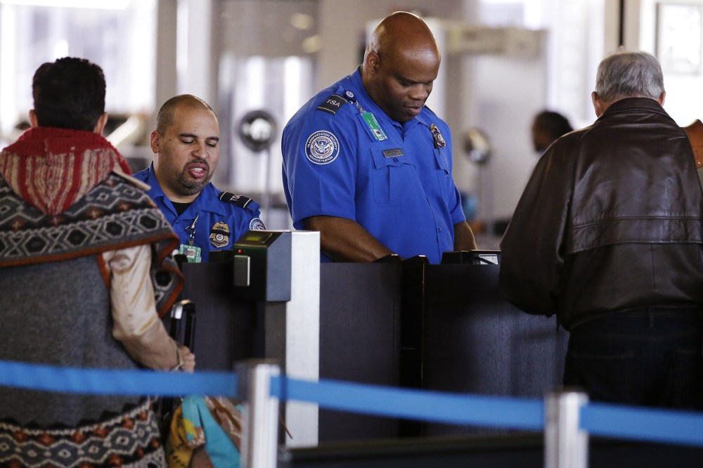 In this Nov. 25, 2015 file photo, TSA agents check travelers' identifications at O'Hare International Airport in Chicago. (Photo by Nam Y. Huh/AP)