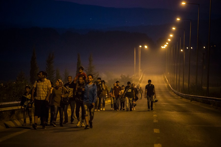 Syrian refugees walk along the roads of the border town of Idomeni, northern Greece to cross the border and enter Macedonia, on Aug. 25, 2015. (Photo by Santi Palacios/AP)