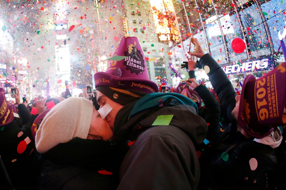 A couple kisses while ringing in the new year at Times Square, Jan. 1, 2016, in New York. (Photo by Julio Cortez/AP)
