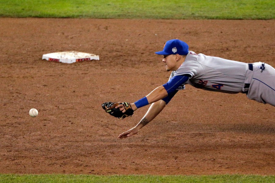 New York Mets shortstop Wilmer Flores unsuccessfully reaches for a Kansas City Royals' Eric Hosmer two-RBI single during the fifth inning of Game 2 of the MLB World Series, Oct. 28, 2015, in Kansas City, Mo. (Photo by Charlie Riedel/AP)