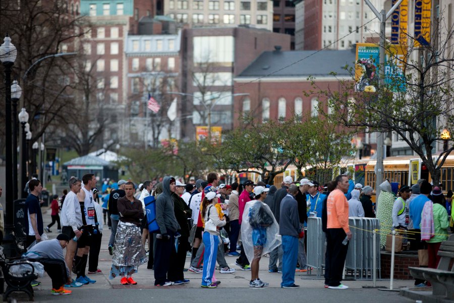 Image: Boston Marathon runners wait to board busses.