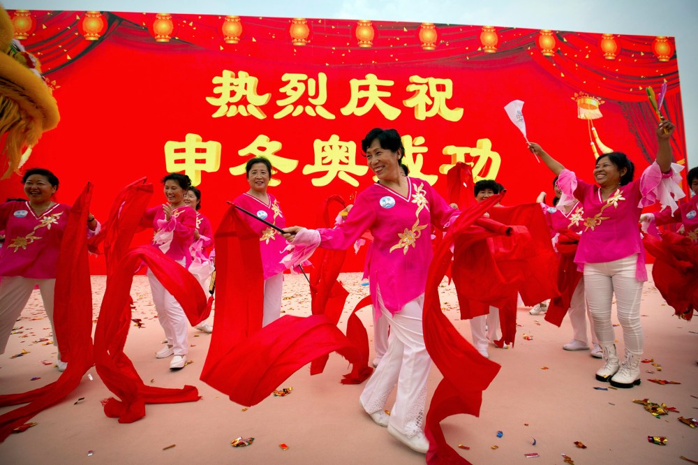 Participants celebrate following the announcement that Beijing will host the 2022 Winter Olympics at a gathering outside the Beijing Olympic Stadium, also known as the Birds Nest, in Beijing, July 31, 2015. (Photo by Mark Schiefelbein/AP)