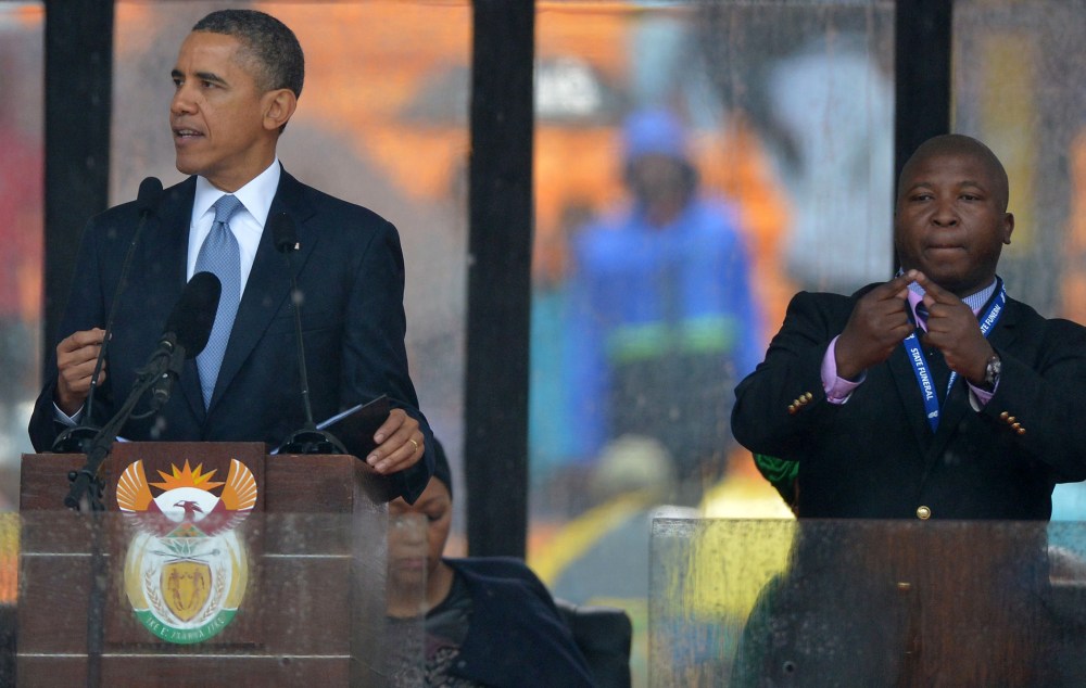 President Barack Obama delivers a speech next to a sign language interpreter during the memorial service for late South African President Nelson Mandela at Soccer City Stadium in Johannesburg, Dec. 10, 2013.