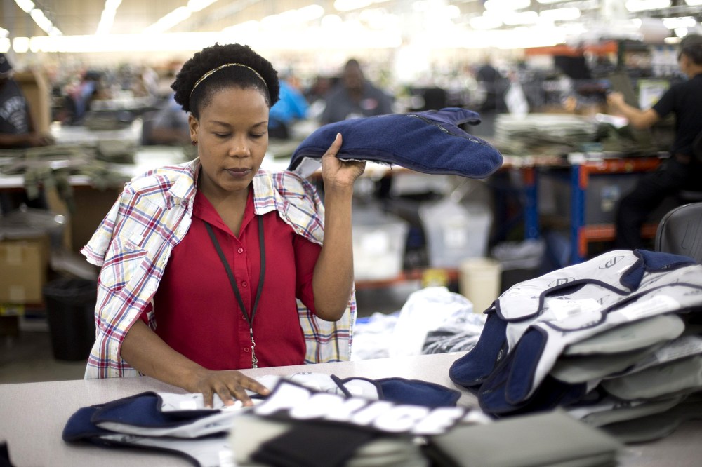 Laurette Eugene makes the final assembly of body armor at the Point Blank Body Armor factory in Pompano Beach, Fla. on Sept. 19, 2014.