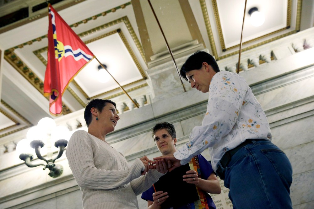 April Dawn Breeden, left, places a ring on the finger of her long-time partner Crystal Peairs, right, as they are married by Rev. Katie Hotze-Wilton on Nov. 5, 2014, at City Hall in St. Louis, Mo.