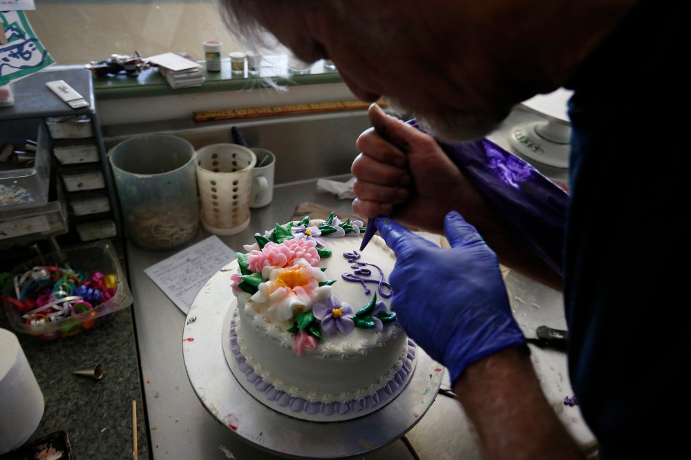Masterpiece Cakeshop owner Jack Phillips decorates a cake inside his store, in Lakewood, Colo.
