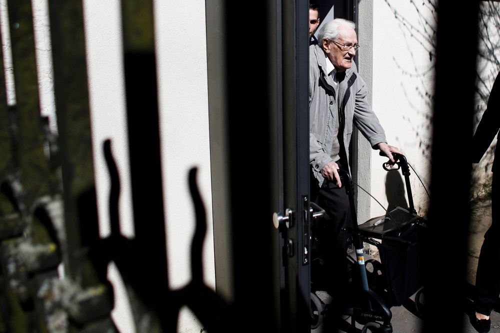 Former SS guard Oskar Groening, center, leaves the court building after the first day of the trial against him in Lueneburg, northern Germany, on April 21, 2015.