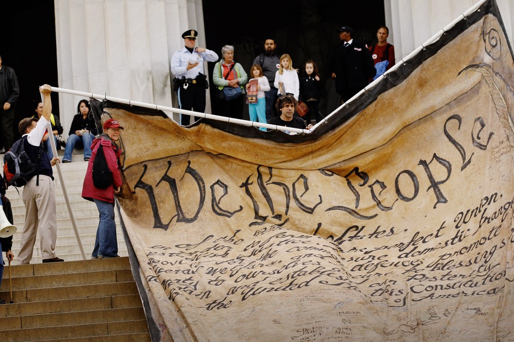 Volunteers unfurl a giant banner printed with the Preamble to the United States Constitution during a demonstration at the Lincoln Memorial on the National Mall Oct. 20, 2010 in Washington, DC. (Photo by Chip Somodevilla/Getty)
