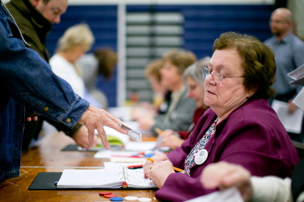 Norma Boyce checks voter identification at a polling station in Manchester, N.H., Nov. 6, 2012. (Photo by Andrew Harrer/Bloomberg/Getty)