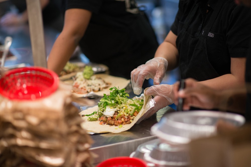 Employees prepare lunch orders at a Chipotle Mexican Grill restaurant. (Photo by Craig Warga/Bloomberg/Getty)