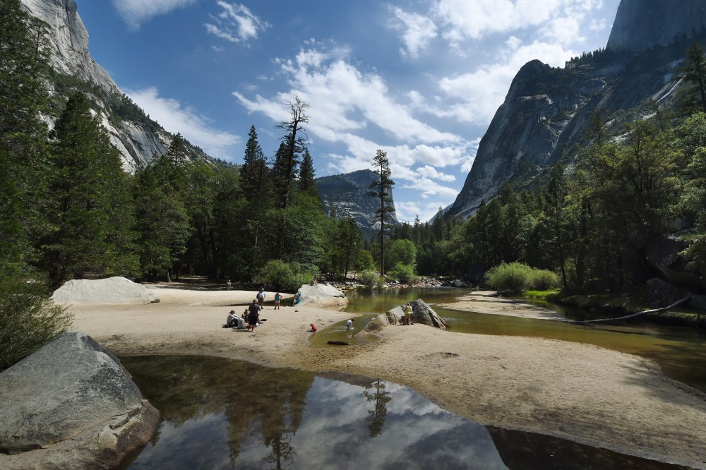 People picnic on the exposed sandy bottom of Mirror Lake that is normally underwater and used by visitors to photograph reflections of the Half Dome rock monolith, June 4, 2015, at Yosemite National Park in Calif. (Photo by Mark Ralston/AFP/Getty)