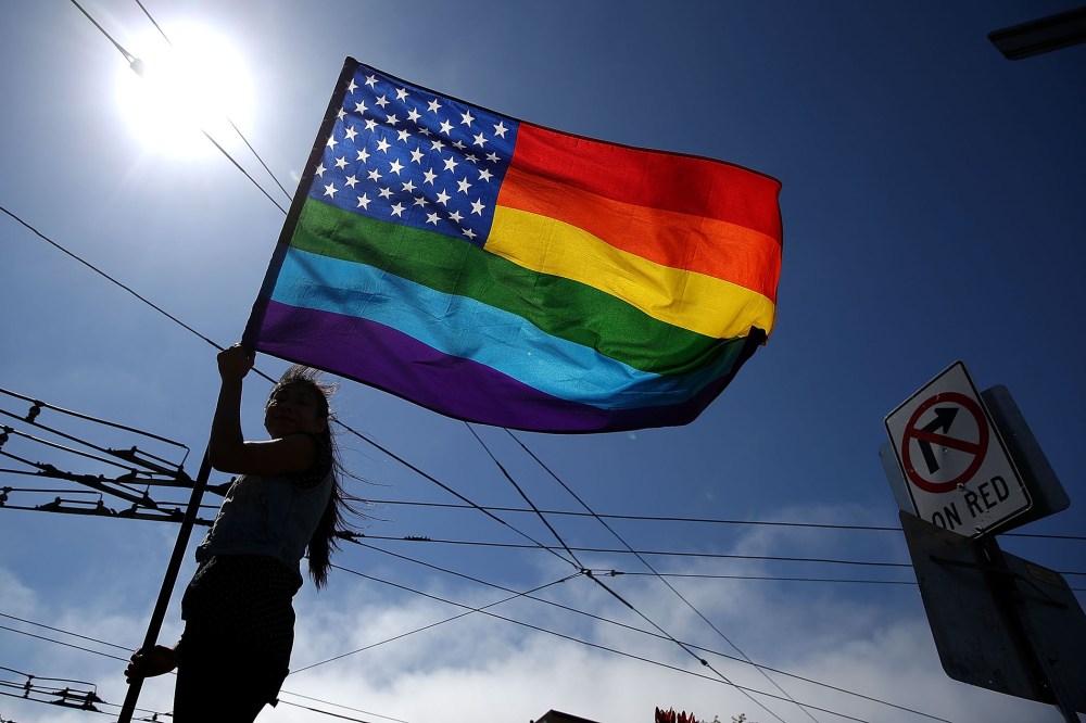 A same-sex marriage supporter waves a pride flag (Photo by Justin Sullivan/Getty).