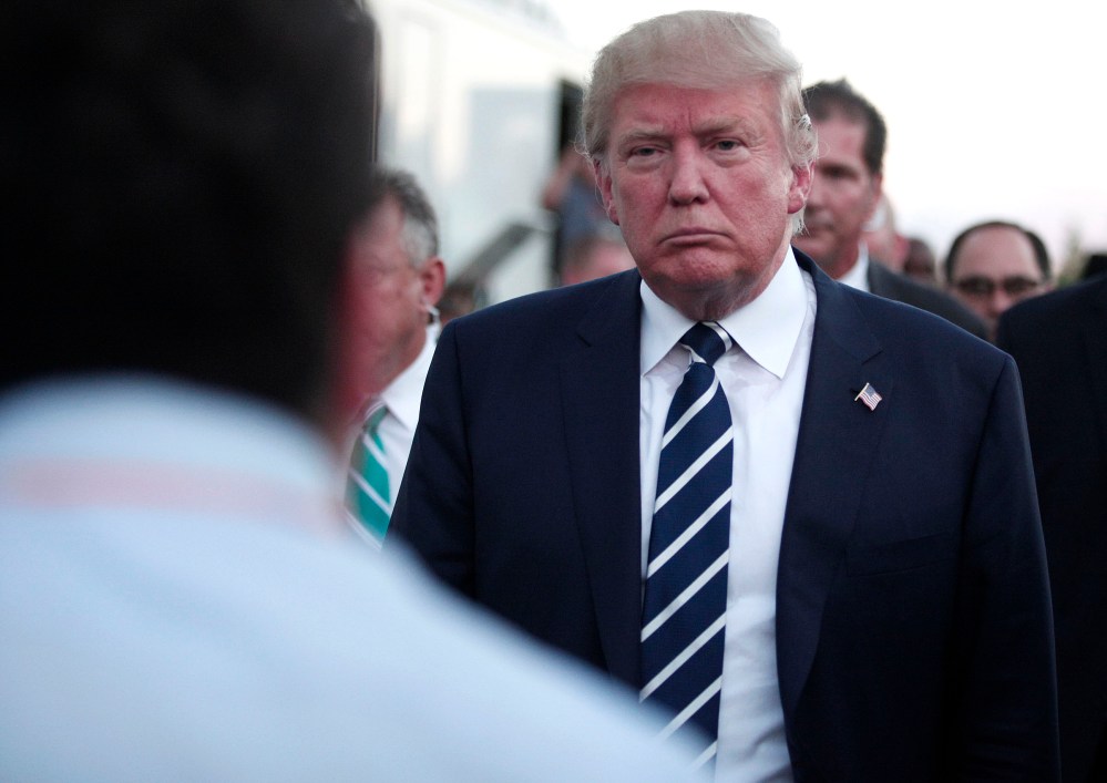 Republican presidential candidate Donald Trump speaks with the media on his way to his car after delivering the keynote address at the Genesee and Saginaw Republican Party Lincoln Day Event, Aug. 11, 2015 in Birch Run, Mich. (Photo by Bill Pugliano/Getty)