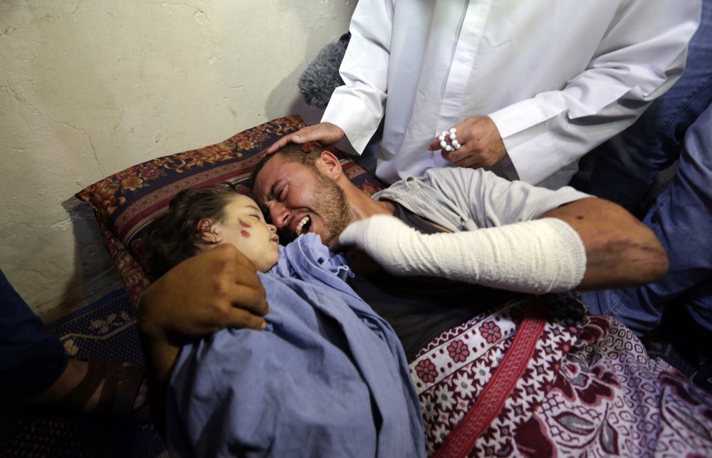 Palestinian father Yehya Hasan mourns while holding the body of his daughter, Rahaf, during a funeral for the toddler and her pregnant mother on Oct. 11, 2015, at the al-Nusairat refugee camp, in central Gaza Strip. (Photo by Mahmud Hams/AFP/Getty)