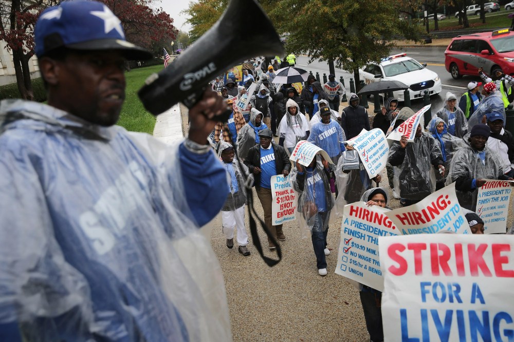 Demonstrators march along Constitution Avenue during a protest to call for higher wages for government contract workers on Capitol Hill Nov. 10, 2015 in Washington, DC. (Photo by Chip Somodevilla/Getty)