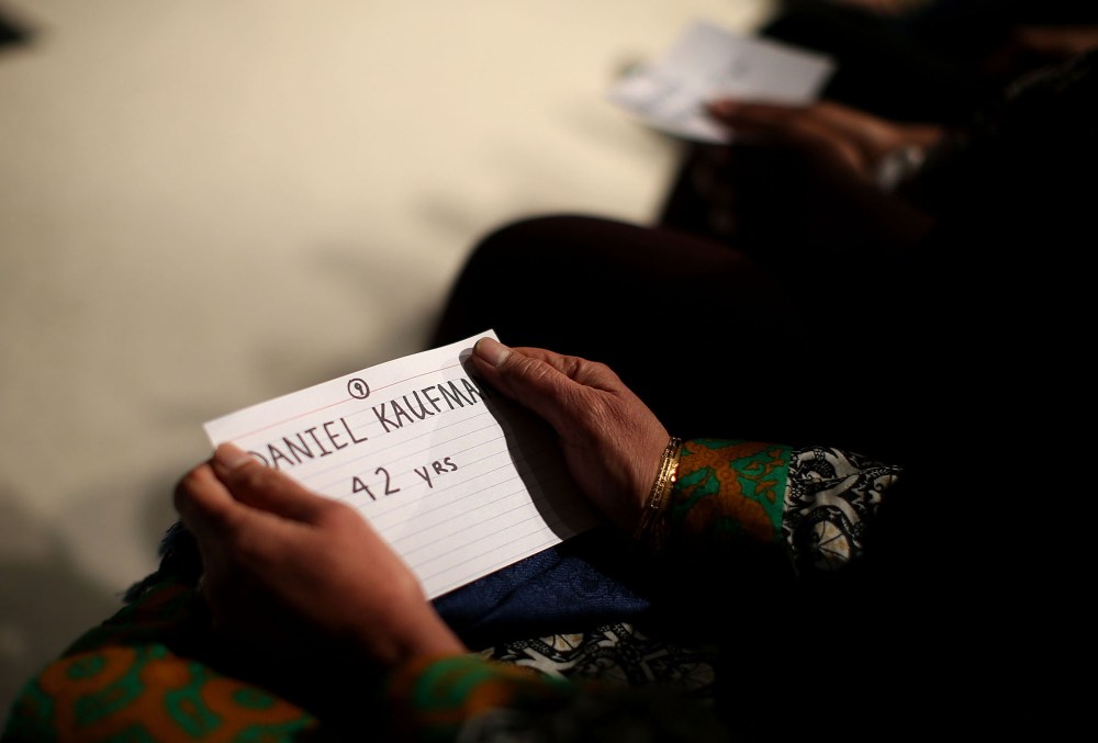 Mourners hold cards with the names of victims of the mass shooting in San Bernardino during a United We Stand vigil at Granada Hills Charter High School on Dec. 5, 2015 in Granada Hills, Calif. (Photo by Justin Sullivan/Getty)