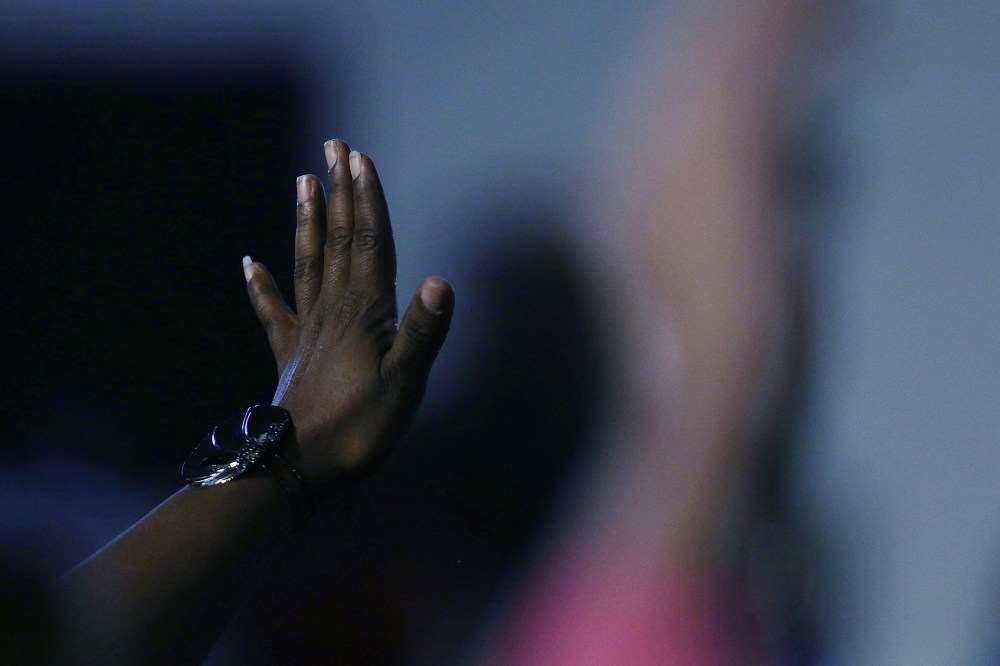 A woman raises her hand to ask a question to Democratic presidential candidate Hillary Clinton as she speaks to voters on Feb. 12, 2016 in Denmark, S.C. (Photo by Spencer Platt/Getty)