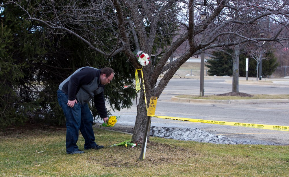 A man places flowers at a Cracker Barrel where a gunman went on a shooting rampage, on Feb. 21, 2016 in Kalamazoo, Mich. (Photo by Tasos Katopodis/Getty)