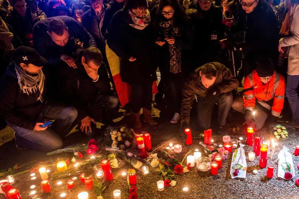 Brussels airport workers and their relatives place candles at a makeshift memorial as they pay tribute to the victims of Brussels triple attacks near the airport in Zaventem on March 23, 2016. (Photo by Philippe Huguen/AFP/Getty)
