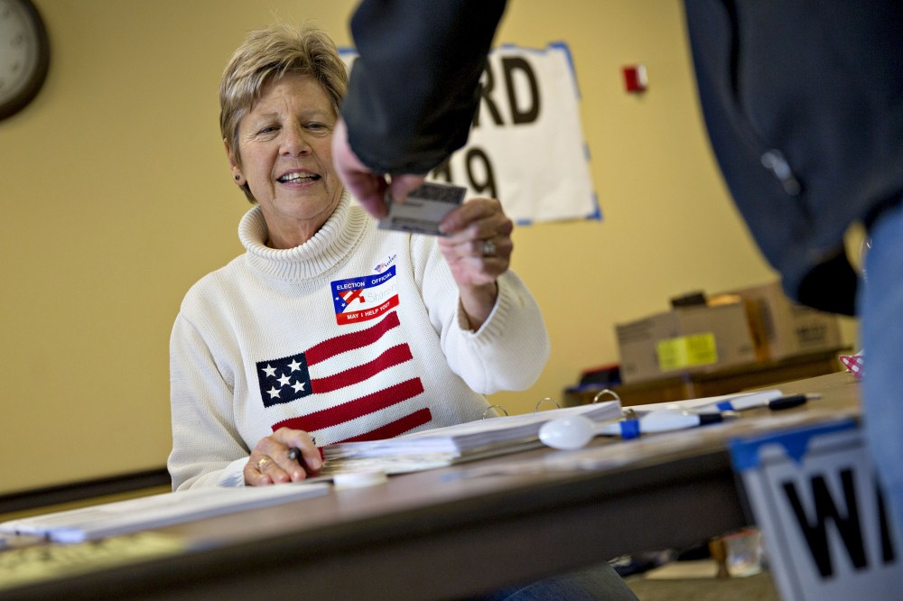 A poll worker checks the identification of a resident at polling location during the presidential primary vote in Waukesha, Wis., April 5, 2016. (Photo by Daniel Acker/Bloomberg/Getty)