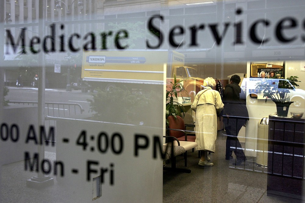 Two people walk inside a Medicare Services office. (Photo by Spencer Platt/Getty)
