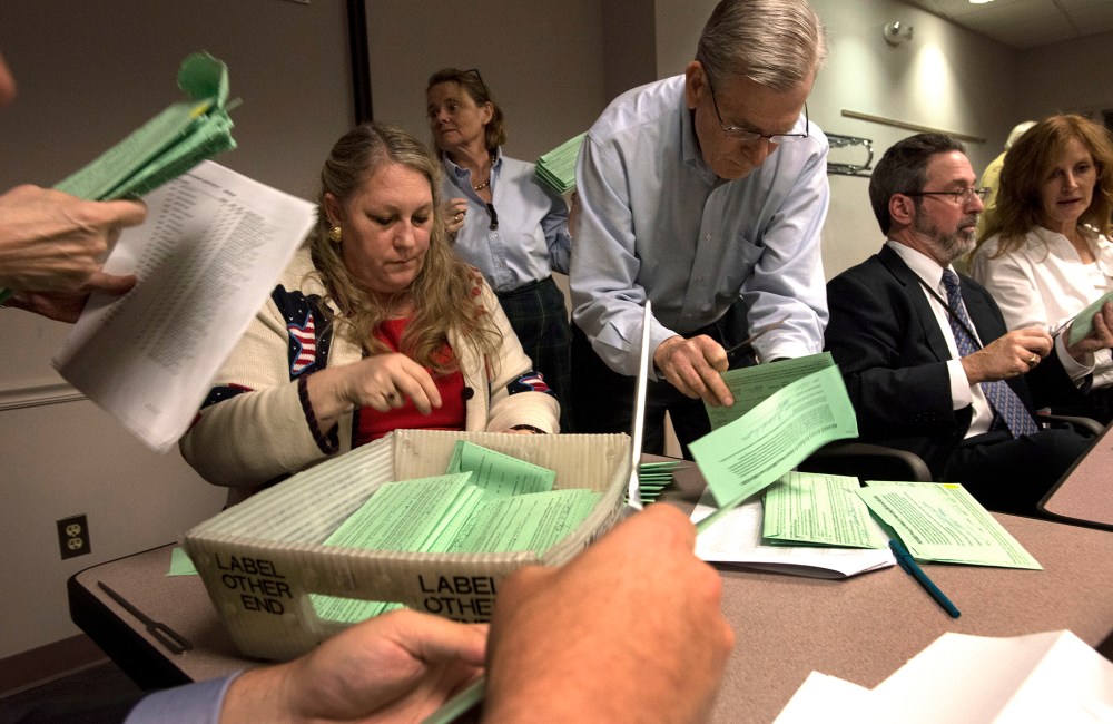 Fairfax County election board employees open provisional ballots from Fairfax County voters for the attorney general race in Fairfax, Va. on Nov. 12, 2013.