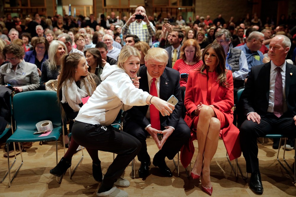 Republican presidential candidate Donald Trump, accompanied with wife, Melania, pauses for a selfie while visiting Saint Francis of Assisi Church, a caucus site, Feb. 1, 2016, in West Des Moines, Iowa. (Photo by Jae C. Hong/AP)