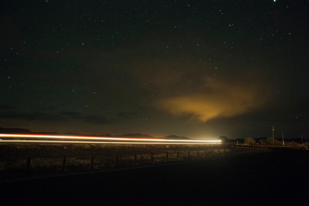 A car drives down the highway at night under a sky full of stars. (Photo by Justin Carrasquillo/Gallery Stock)