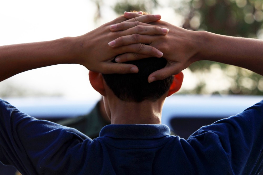 A young boy waits as Border Patrol agents process a group of 22 migrants who just crossed the Rio Grande near McAllen, Texas, June 18, 2014.