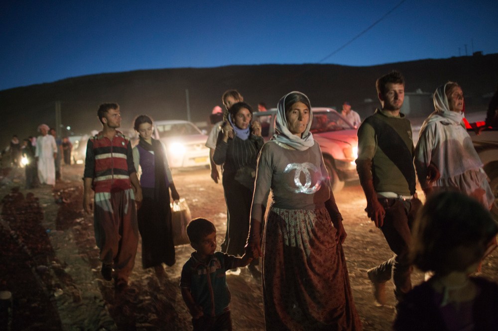 Refugees from the Yazidi religious minority cross the Syrian border into Faysh Khabur, in Iraq's northern Dohuk province on Aug. 9, 2014. (Adam Ferguson/The New York Times/Redux)