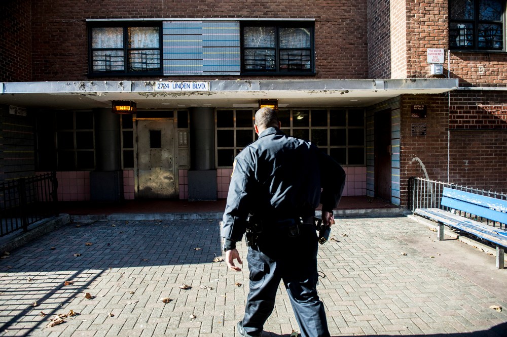 An officer outside the Louis H. Pink Houses, where a man was shot dead by police the night before, in the Brooklyn borough of New York, Nov. 21, 2014. (Photo by Robert Stolarik/The New York Times/Redux)