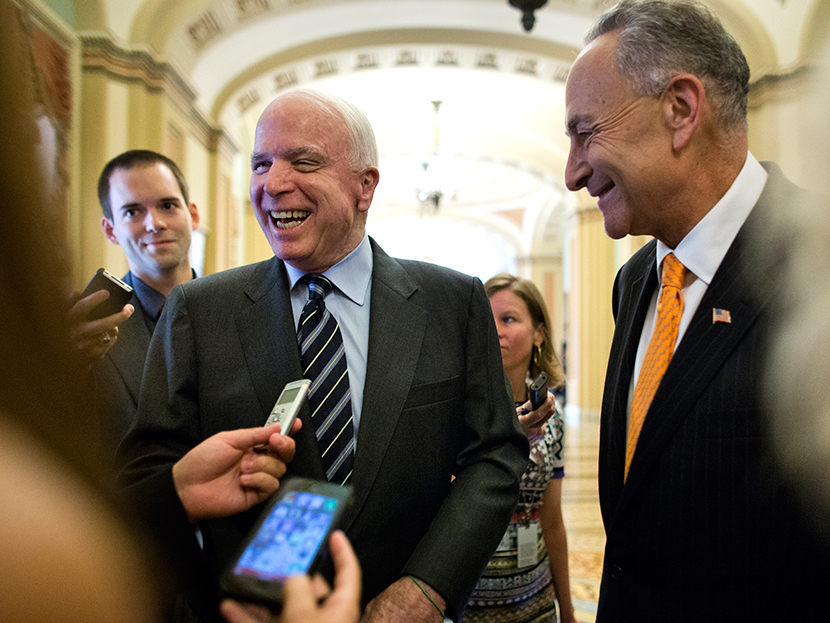 Republican Senator from Arizona John McCain (L) and Democratic Senator from New York Chuck Schumer (R) talk with the media outside the Senate chamber after the immigration bill passed a crucial vote to move forward to a final vote in the US Capitol in...