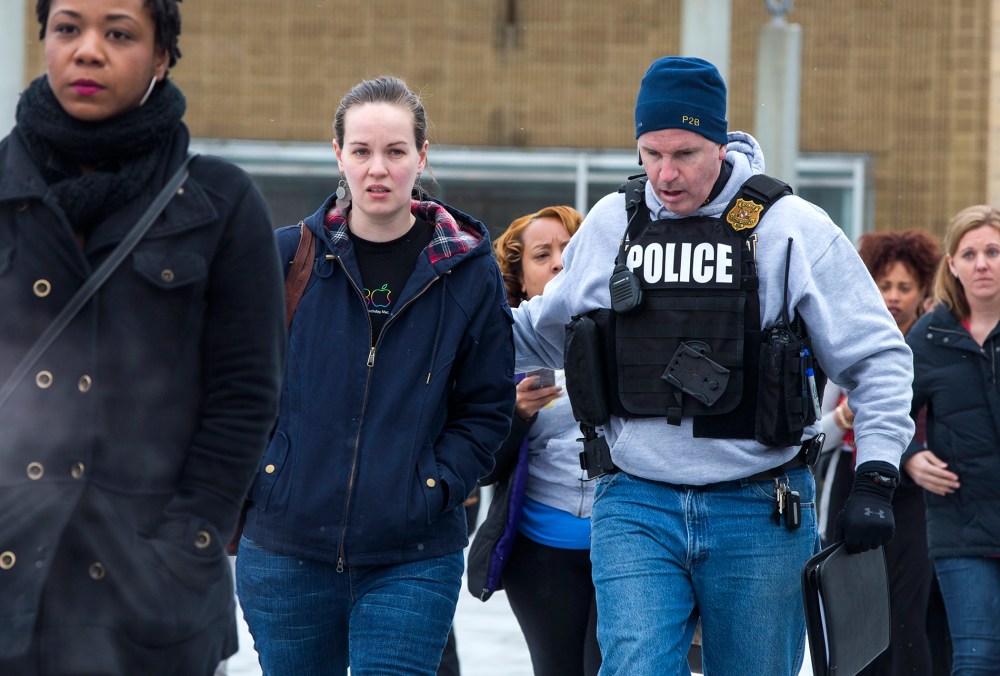 Police escort shoppers and employees out of the Columbia Mall after a shooting left three people dead, Jan. 25, 2014, in Columbia, Md.
