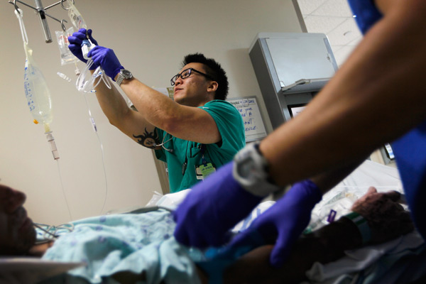 Registered Nurse Tung Tran hangs an I.V. bag for a patient at the University of Miami Hospital's Emergency Department on April 30, 2012 in Miami, Florida. (File photo by Joe Raedle/Getty Images)