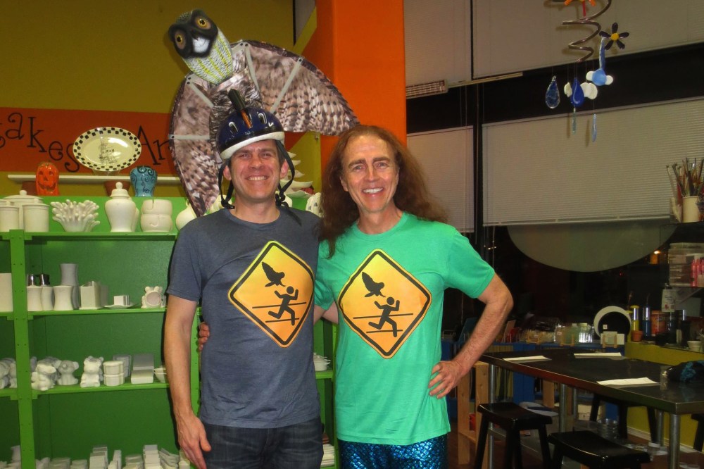 Dr. Ron Jaecks, owl attack-surviving jogger, poses with a homemade owl warning sign t-shirt.
