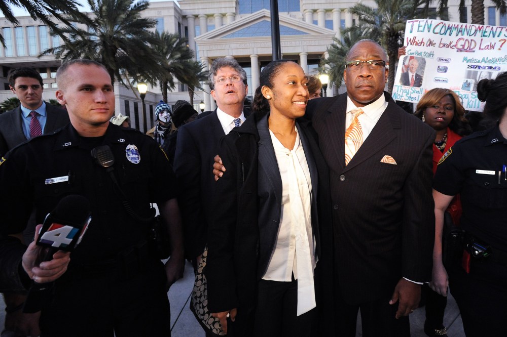 Marissa Alexander walks by her dad Raoul Jenkins and surrounded by her legal team and supporters after her sentencing in Jacksonville, Fla., Jan. 27, 2015. (Photo by Bob Mack/Florida Times-Union/AP)