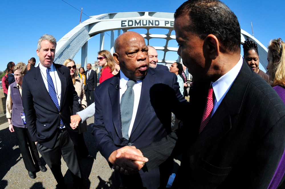 U.S. Rep. John Lewis, D-Ga., center, is greeted by a well wisher as he pauses for a photo opportunity with members of the the Kennedy family prior to commemorating the 47th anniversary of the "Bloody Sunday" civil rights march from Selma to Montgomery...