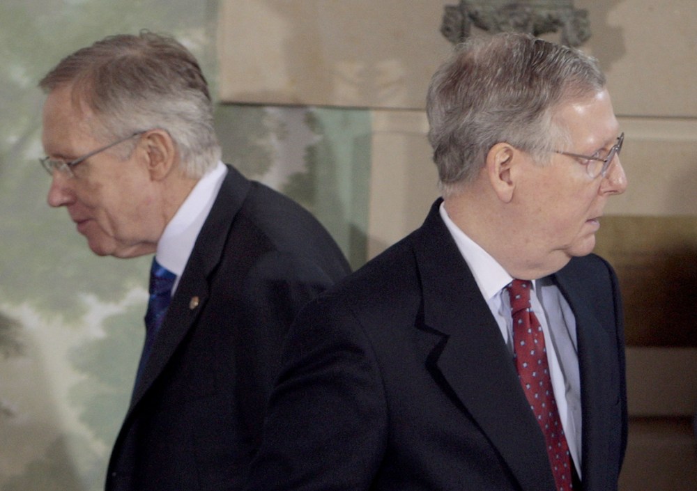 Senate Majority Leader Harry Reid of Nev., left, walks past Senate Minority Leader Mitch McConnell of Ky. (Photo by Pablo Martinez Monsivais/AP)