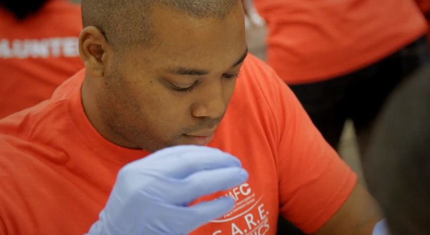 A volunteer for the National Association of Free & Charitable Clinics helps a patient. (Image via NAFC)
