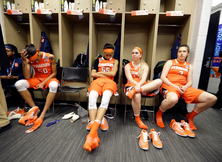 Syracuse players, from left to right, Briana Day, Bria Day, Savannah Crocetti and Julia Chandler sit in the locker room following their 82-51 loss to Connecticut (Photo by Michael Conroy/AP)
