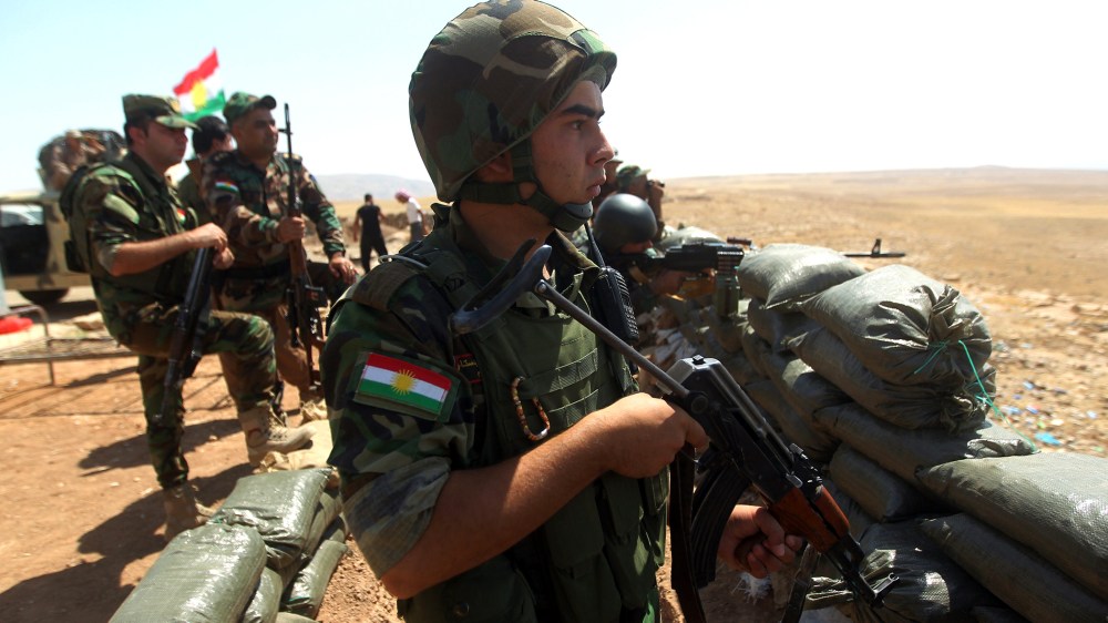 Iraqi Kurdish Peshmerga fighters take position as they monitor the area from their front line position in Bashiqa, a town 13 kilometres north-east of Mosul on Aug. 16, 2014.