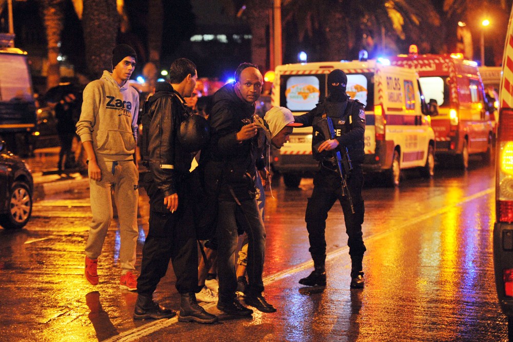 Family members of victims of a bomb blast on a bus transporting Tunisia's presidential guard in central Tunis react at the site of the attack on Nov. 24, 2015. (Photo by Fethi Belaid/AFP/Getty)