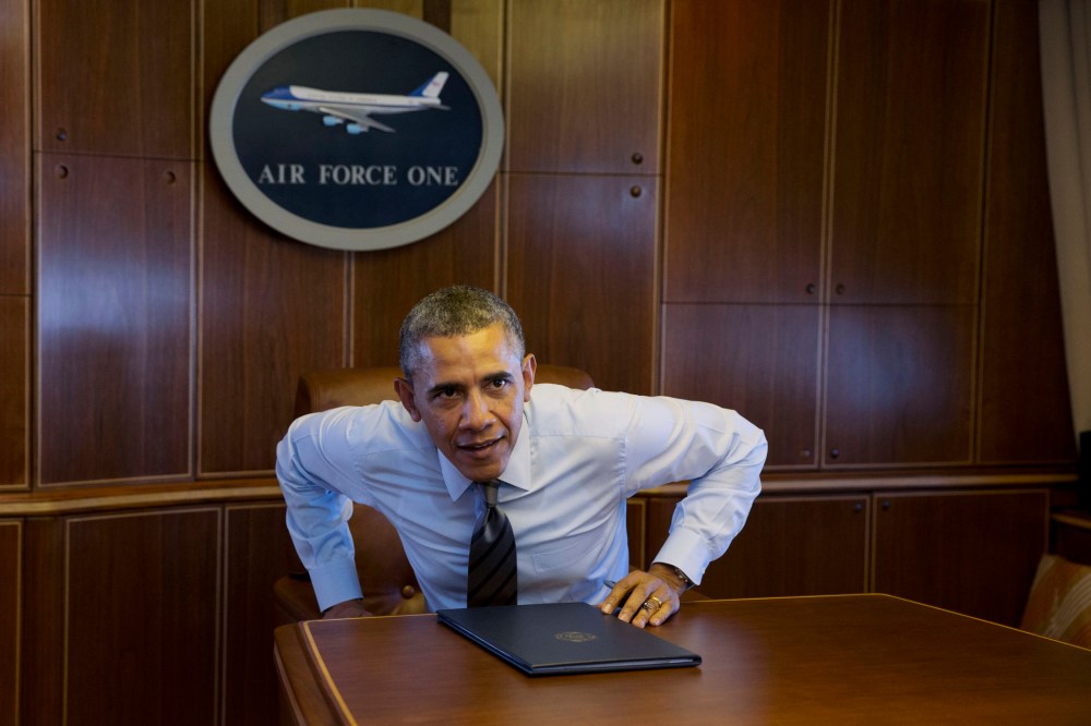 President Barack Obama prepares to walk away from a table, Wednesday, Feb. 19, 2014, in a conference room in flight aboard Air Force One.
