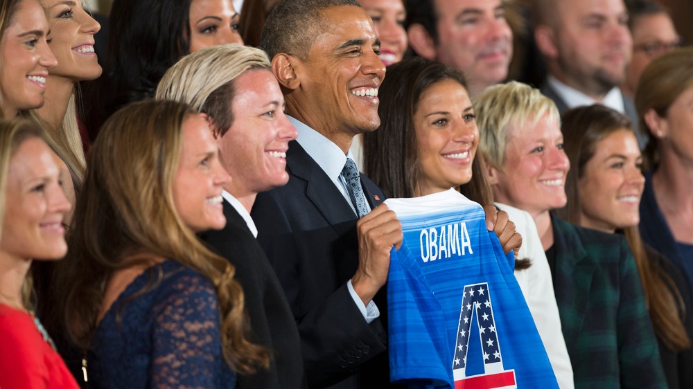 President Barack Obama holds a jersey and poses for photographs during a ceremony to honor the 2015 FIFA Women's World Cup champion U.S. National Soccer Team, Oct. 27, 2015, in the East Room of the White House in Washington, D.C. (Photo by Evan Vucci/AP)