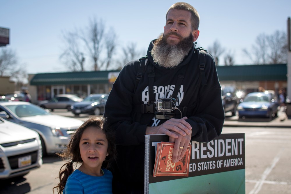 Toby Harmon, member of Abolish Human Abortion, stands with his child outside Norman High School in Norman, Oklahoma on Feb. 21, 2014.