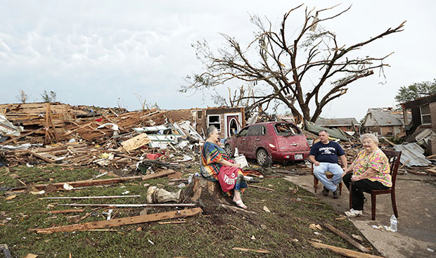 MOORE, OK - MAY 20:  (L - R) Yvonne Barragar, Joe Marshall and Barbara Garcia sit in front of Barragar's destroyed house after a powerful tornado ripped through the area on May 20, 2013 in Moore, Oklahoma. The tornado, reported to be at least EF4...