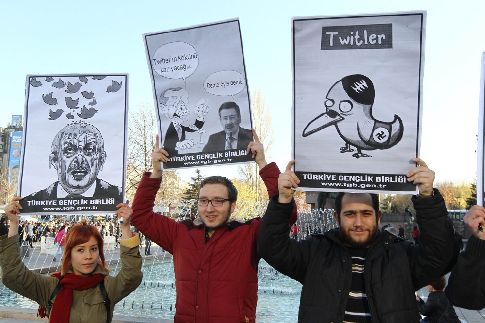 People hold placards as they protest against Turkey's Prime Minister Tayyip Erdogan after the government blocked access to Twitter in Ankara, on March 21, 2014.