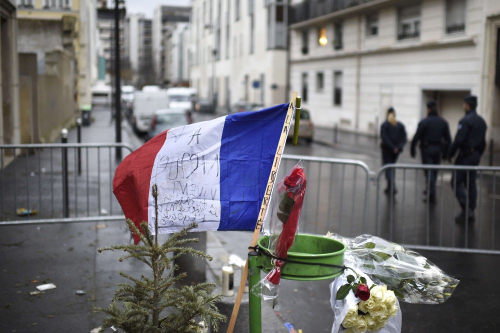 A French flag reading "to Liberty" is placed near a barrier outside the offices of French satirical newspaper Charlie Hebdo in Paris on Jan. 8, 2015.